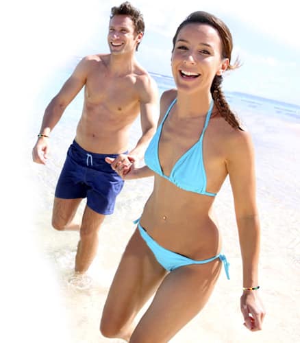 Couple heureux sur la plage avec bracelets énergie